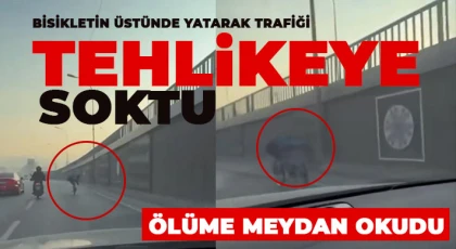 Bisikletin üstünde yatarak trafiği tehlikeye soktu